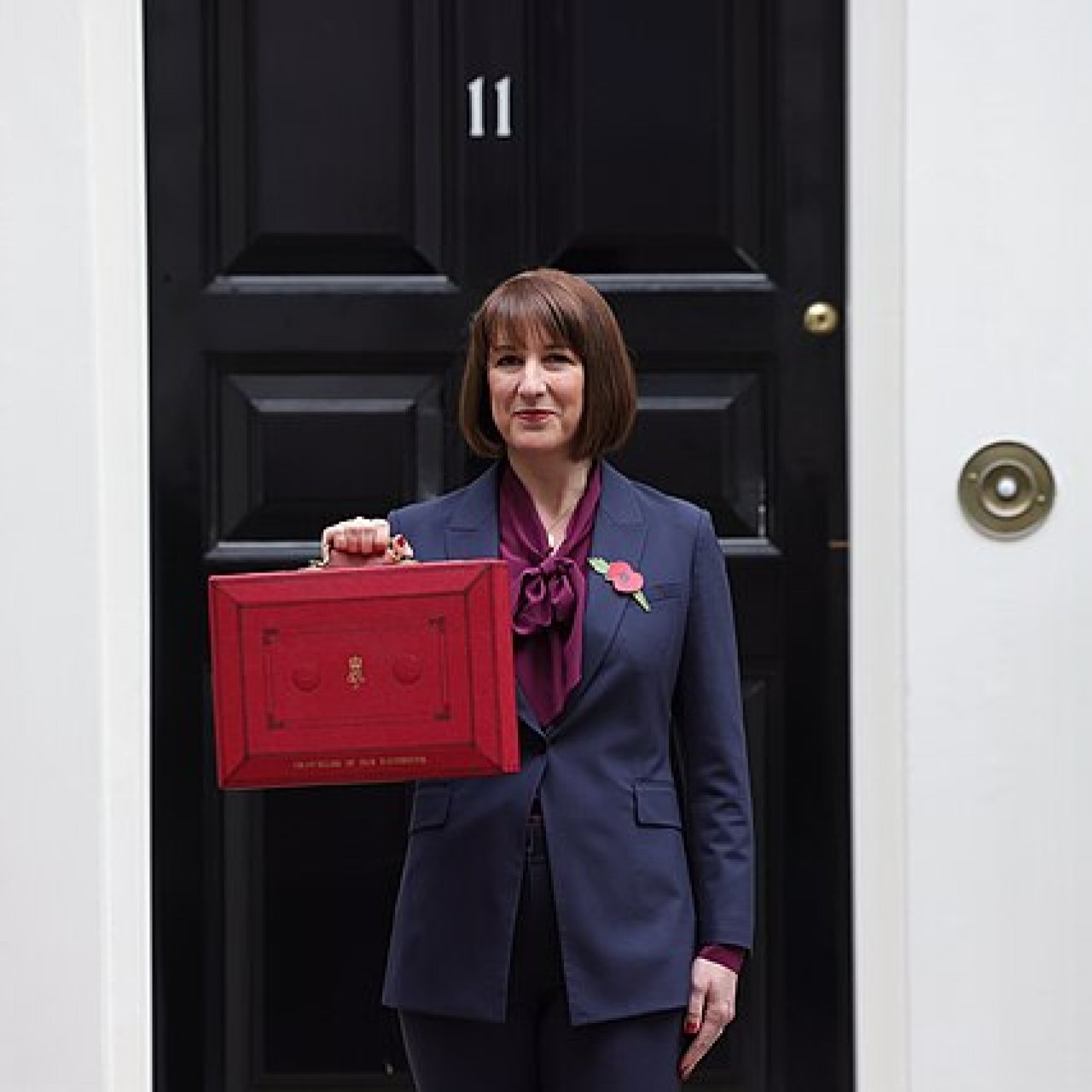 Labour Budget 2024: This image shows Rachel Reeves, Chancellor for the UK Labour government, holding up the famous red 'Budget Briefcase', in front of number 11 Downing Street.